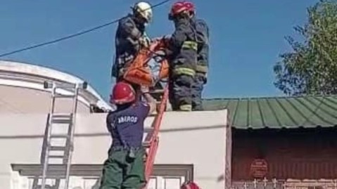 Los bomberos rescataron a una persona herida en el techo de su casa